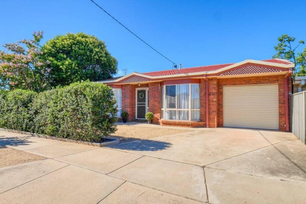 a red brick house with a garage at Beautiful Bala in Shepparton