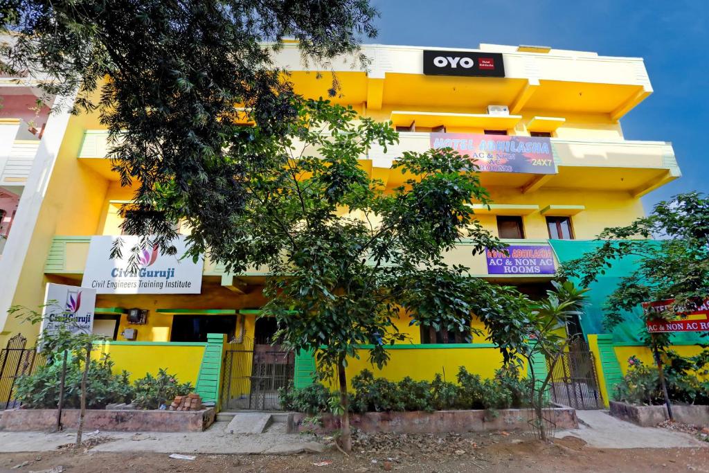 Bhilai的住宿－OYO Hotel Abhilasha，黄色的建筑,旁边标有标志