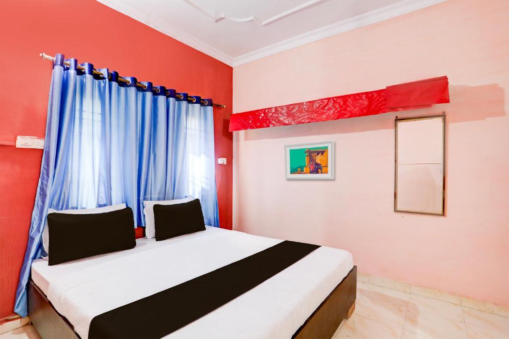 a bedroom with a bed with red walls and a window at OYO Hotel Abhilasha in Bhilai