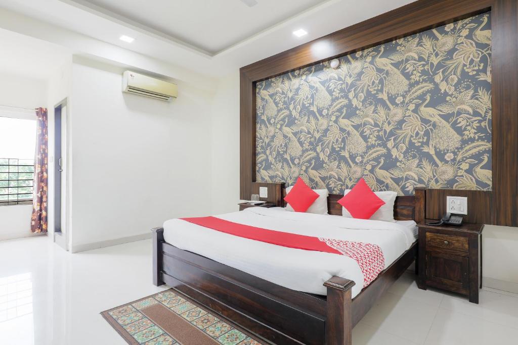 a bedroom with a bed and a large wall at OYO HOTEL SHOOLIN in Indore
