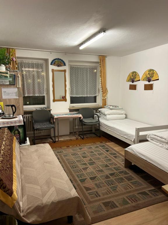 sala de estar con camas, mesa y sillas en China-Ferienzimmer, en Berchtesgaden