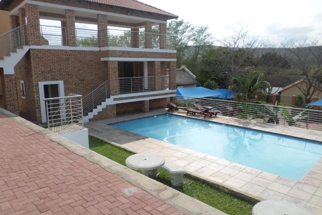 a large swimming pool in front of a house at Country Link Guest Lodge in Komatipoort