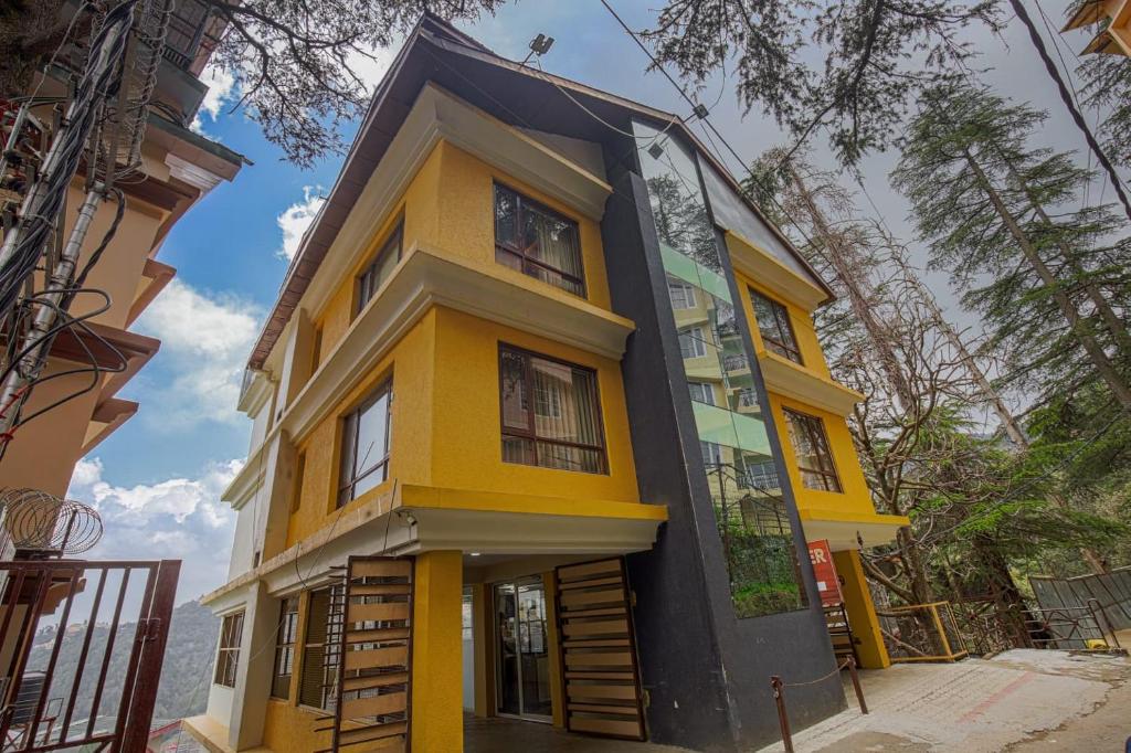 a yellow and black house with a blue at Mahaveer Shimla By Royal Collection Hotels in Shimla