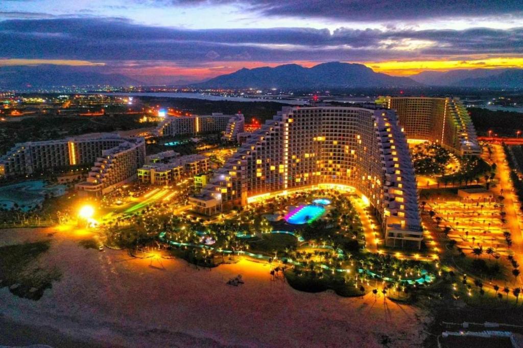 Arena Apart-Resort Cam Ranh with Ocean view-Private beach في كام رنه: اطلالة على منتجع في الليل مع انارة