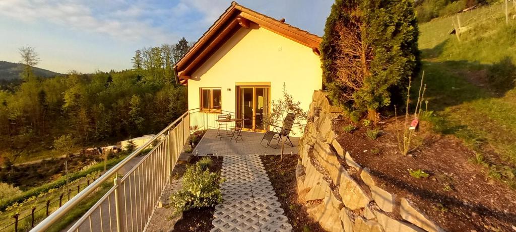 ein kleines Haus auf einem Hügel mit einer Steinmauer in der Unterkunft Schwarzwaldglück in Oberkirch