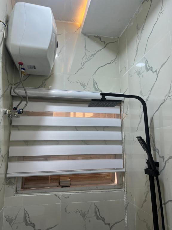 a bathroom with a hair dryer on the wall at HighX Hotels in Port Harcourt