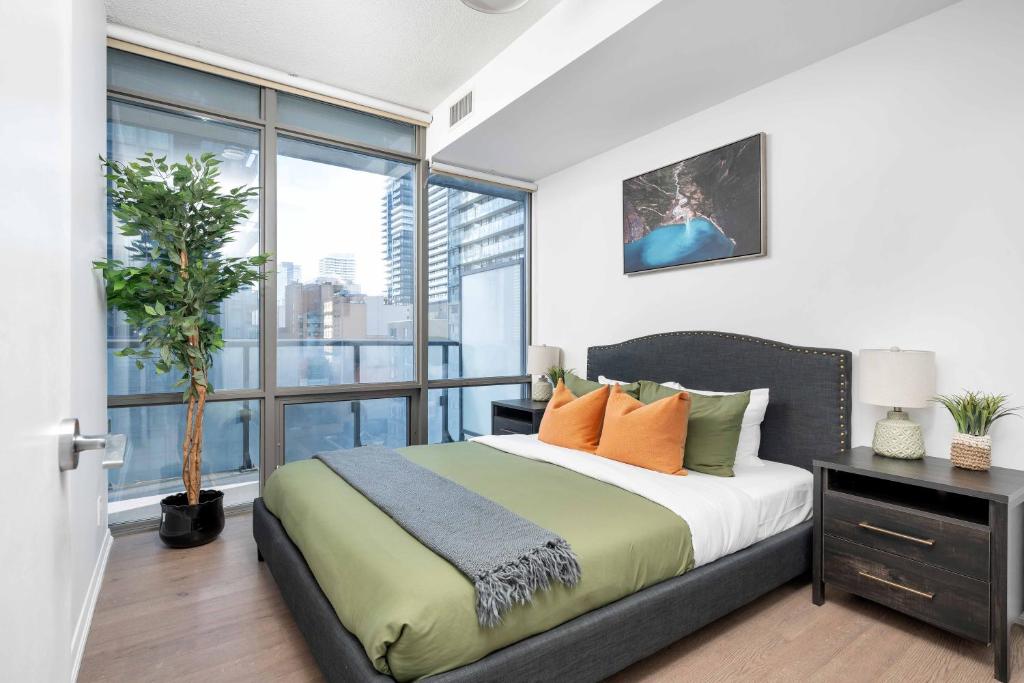 um quarto com uma cama e uma grande janela em Spacious 2BR+2BA w/ 4 Beds Near Yorkville! em Toronto