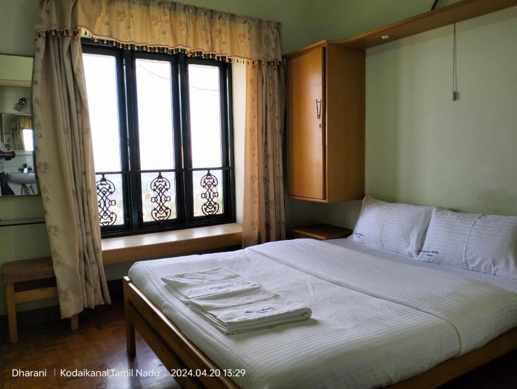 a bedroom with a large bed with a window at Kodai Serenvilla in Kodaikānāl