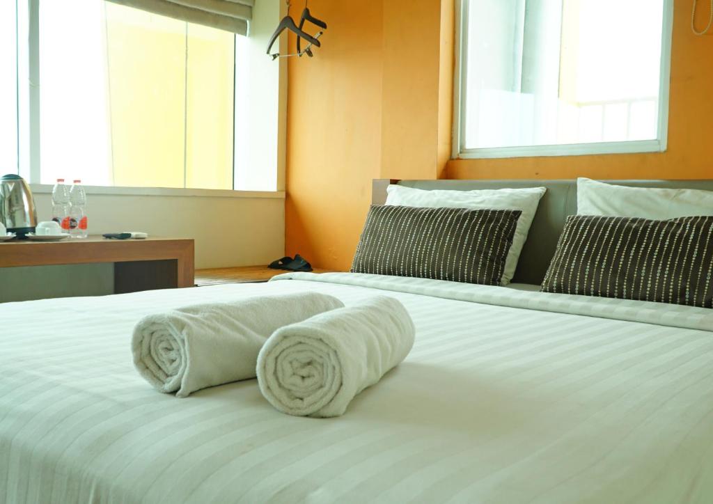 two white towels on a bed in a room at World Hotel Jakarta - Bandengan in Jakarta