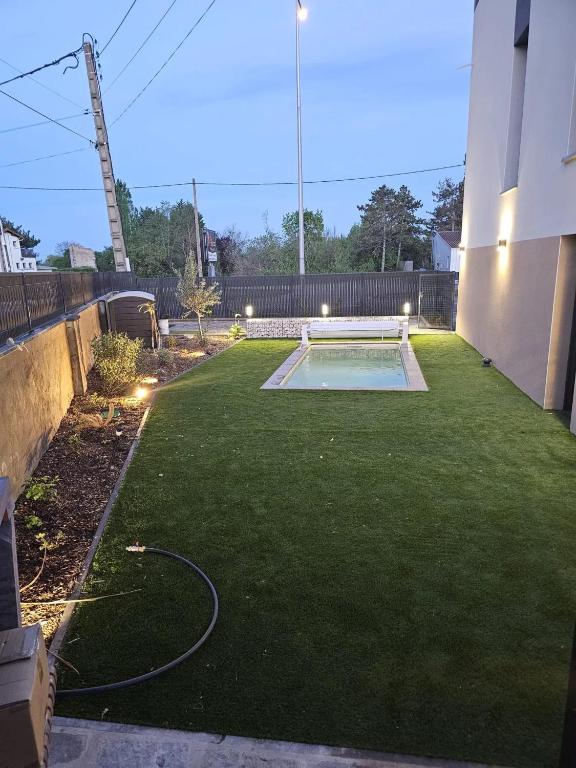 a backyard with a pool and a lawn with lights at Villa de 4 chambres avec piscine privee sauna et jardin clos a Riom in Riom