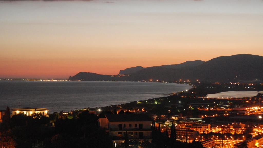 a view of a city and the ocean at night at Hotel Belvedere in Sperlonga