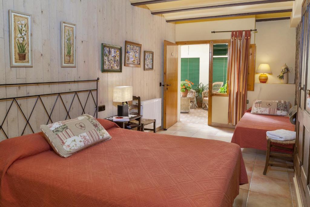 een slaapkamer met 2 bedden en een deur naar een patio bij Casa Rural Can Coll in Garriguella