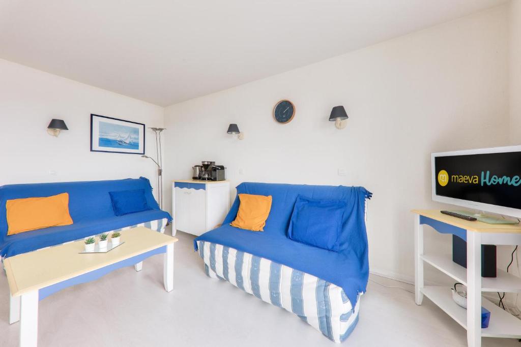 - un salon avec deux canapés bleus et une télévision dans l'établissement Port du Crouesty Cap'Océan - maeva Home - Appartement 3 pièces 6 personnes - Sélection - super Home MAE-3541, à Arzon