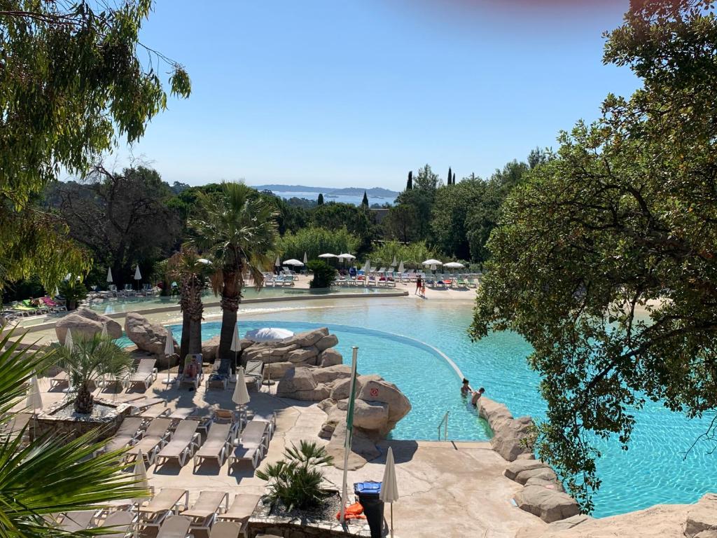 a large swimming pool with chairs and people in it at Appartement région de St-Tropez in Grimaud