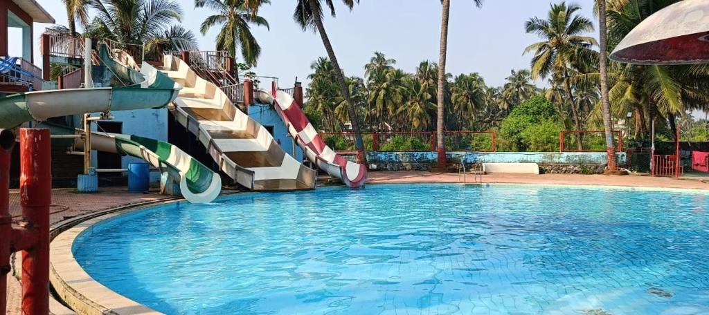 een zwembad met glijbaan in een resort bij Tulsi Paradise Resort in Nirmal
