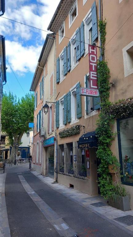 a building with a sign on the side of a street at Hôtel Saint-Florent, à 2 pas du Théatre Antique d'Orange in Orange
