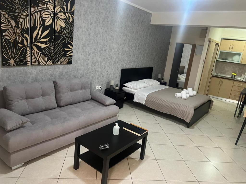 a living room with a couch and a bed at AVR Airport Deluxe Suites 4 in Markopoulo