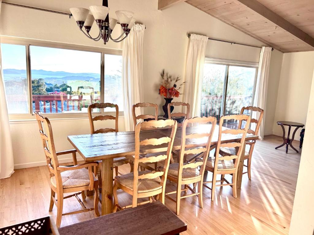 a dining room with a table and chairs and windows at Sunset View in El Cerrito
