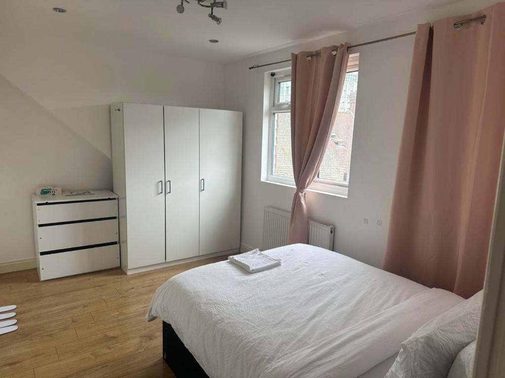 倫敦的住宿－Tran UK Homestay，一间卧室配有一张床、一个梳妆台和一扇窗户。