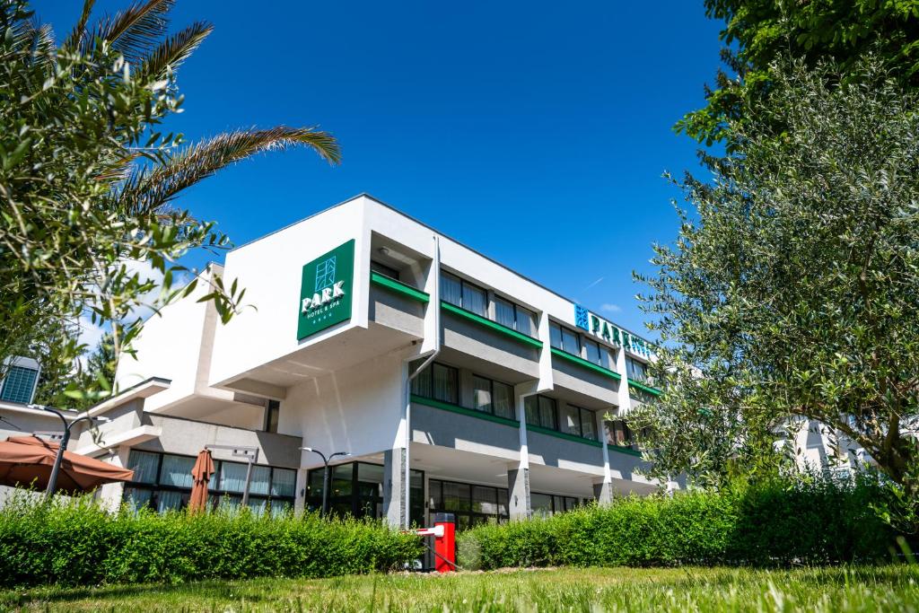 - un bâtiment blanc avec un panneau vert dans l'établissement PARK Hotel & SPA Jablanica, à Jablanica