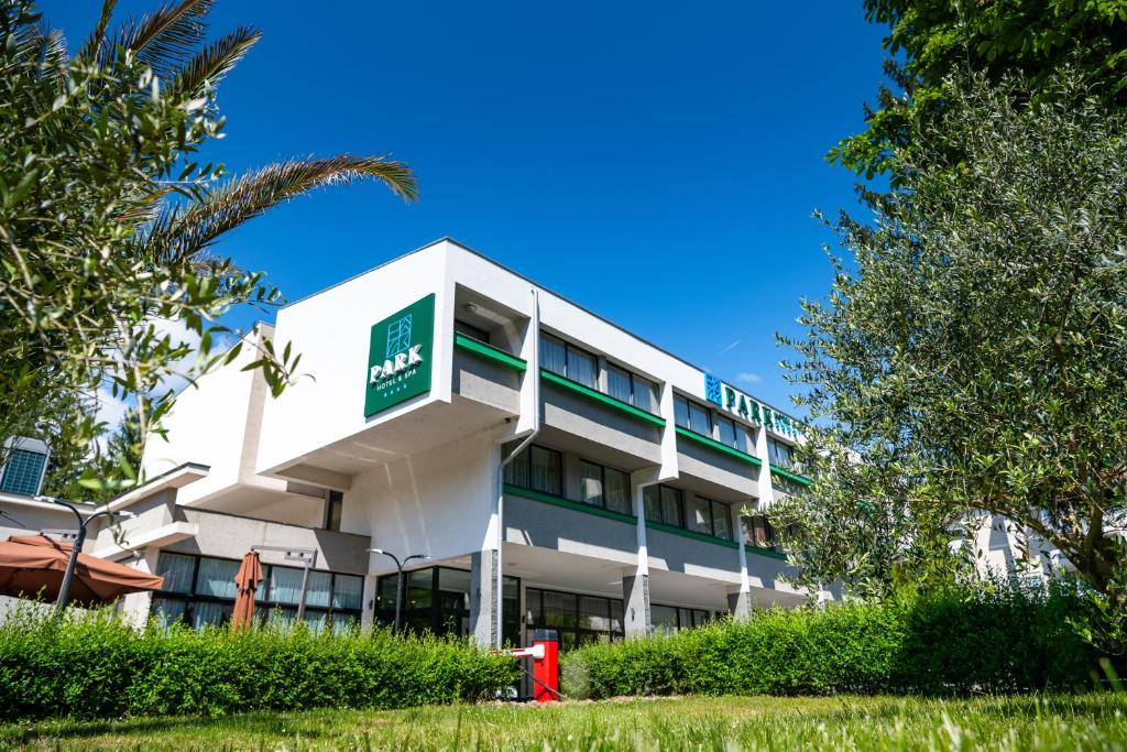 um edifício branco com um sinal verde em PARK Hotel & SPA Jablanica em Jablanica