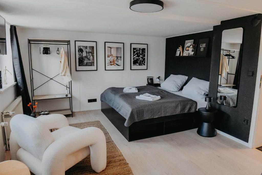 ein Schlafzimmer mit einem Bett und einem Stuhl darin in der Unterkunft sleepArt Black&White in Celle
