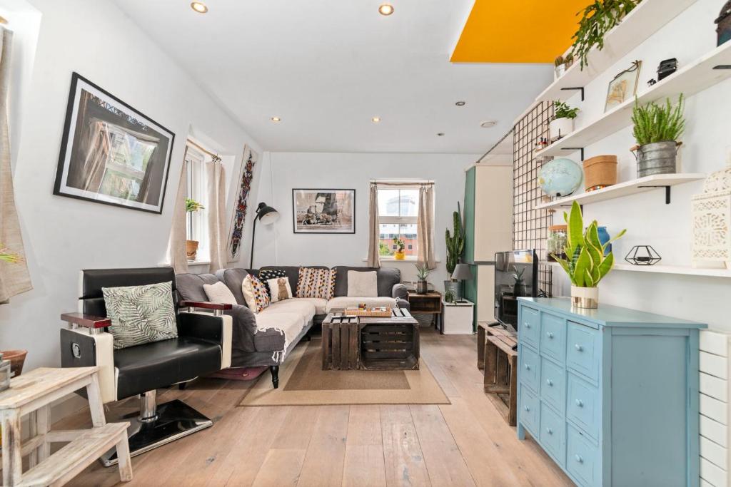 een woonkamer met een bank en een tafel bij GuestReady - Artsy Penthouse in Heart of the City in Londen