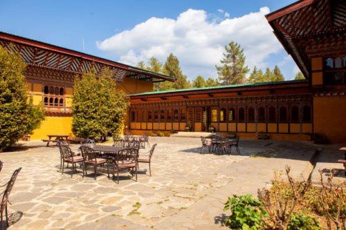 a patio with tables and chairs in front of a building at Hotel Olathang in Paro