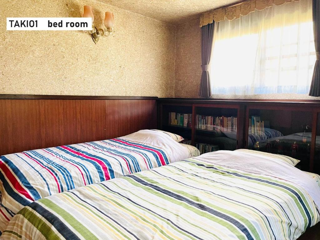 two beds sitting next to each other in a bedroom at TAKIO Guesthouse - Vacation STAY 06377v in Higashi-osaka