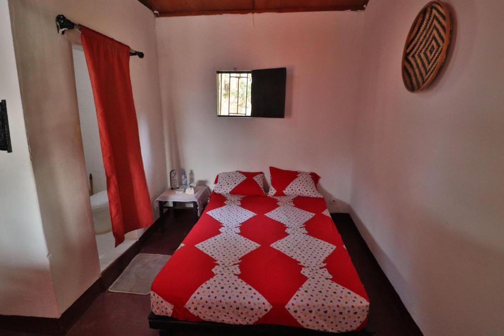 a red bed in a room with a window at Kiriboungni chez sylfatou in Tahire