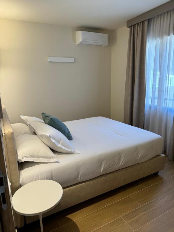 a bedroom with a bed and a table and a window at Résidence CATALINA in Saint-Florent