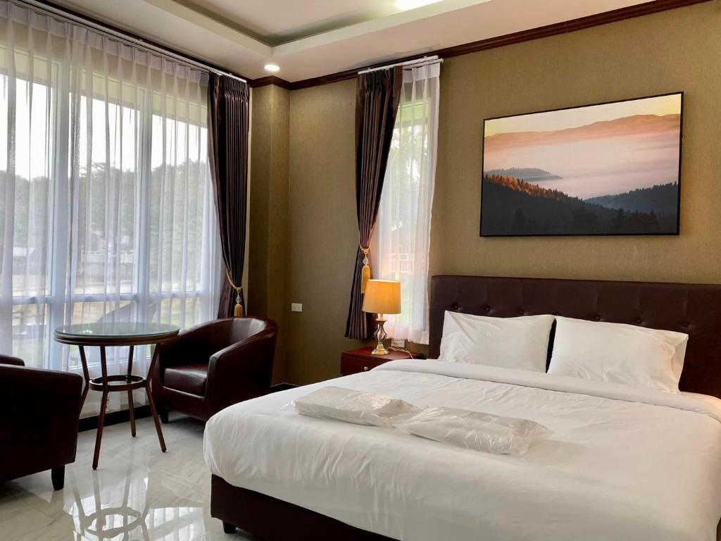 een hotelkamer met een groot bed en een tafel bij ช่องแคบ เดอ เมาท์เท่น รีสอร์ท in Ban Huai Nam Nak