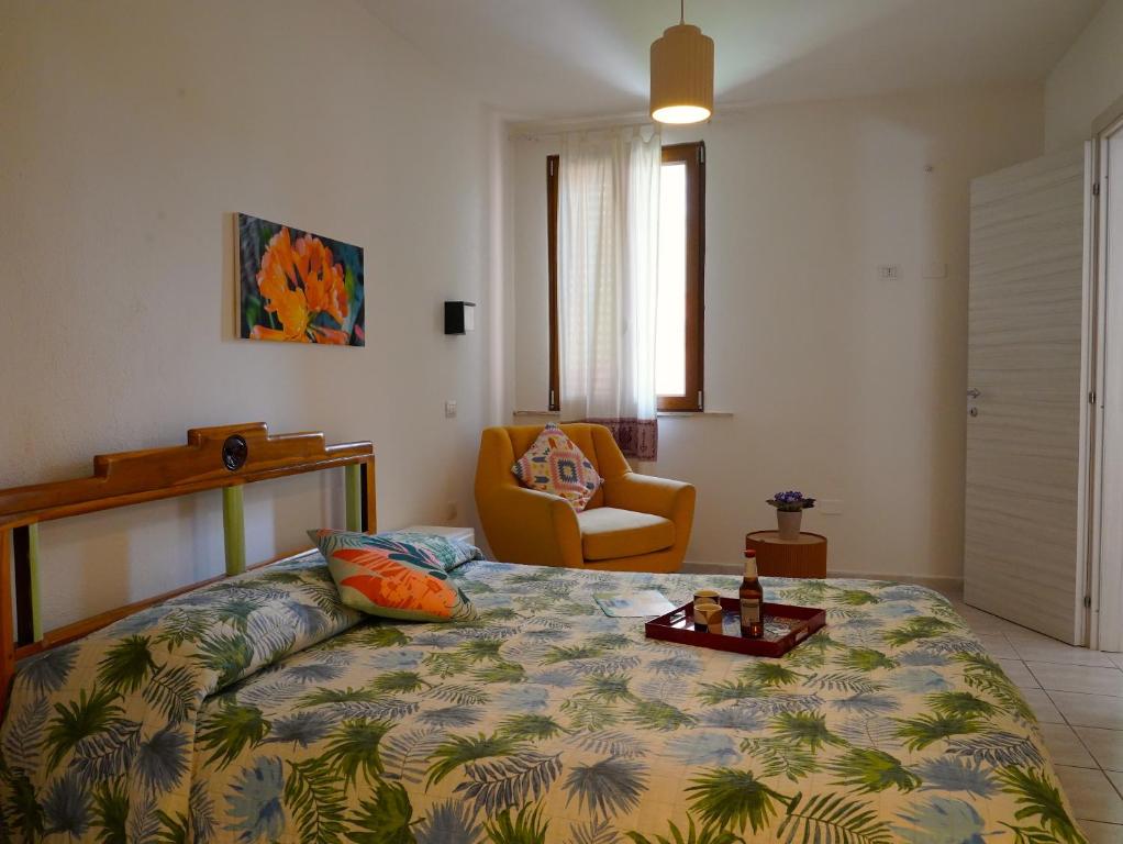 a bedroom with a bed and a chair at Flowery Inn Villa in Alghero