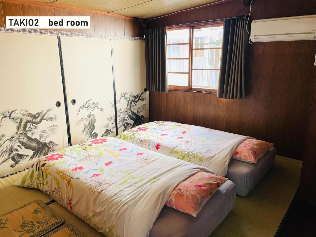 um quarto com 2 camas e uma janela em TAKIO Guesthouse - Vacation STAY 11600v em Higashi-osaka