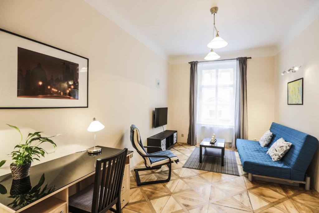 ein Wohnzimmer mit einem blauen Sofa und einem Tisch in der Unterkunft Accommodation Smečky 14 in Prag