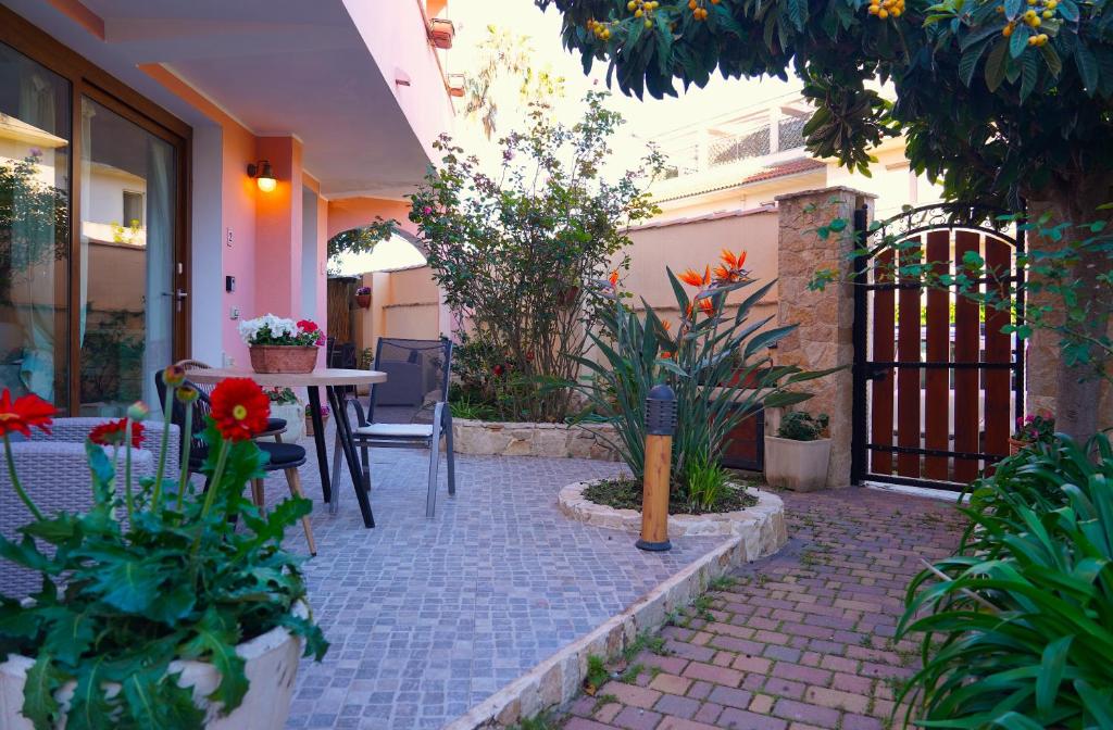 a courtyard with a table and chairs and flowers at Flowery Inn Villa in Alghero