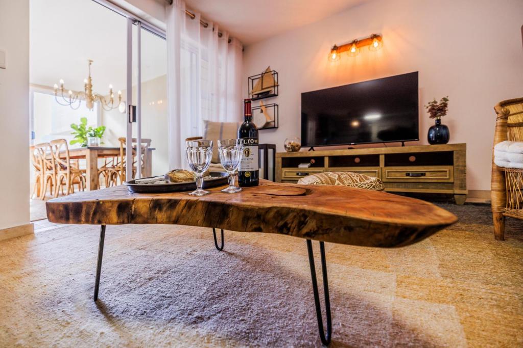 a living room with a wooden table with wine glasses at Soul Season Unit 21 in Swakopmund