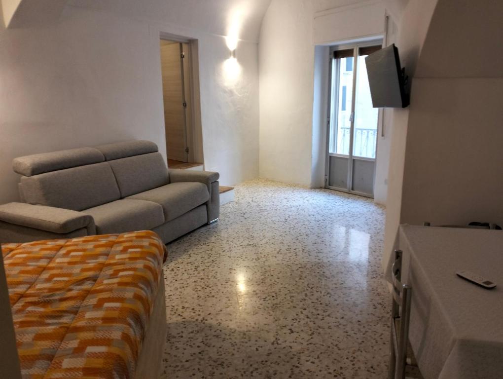 salon z kanapą i telewizorem w obiekcie Stone Rooms w mieście Matera