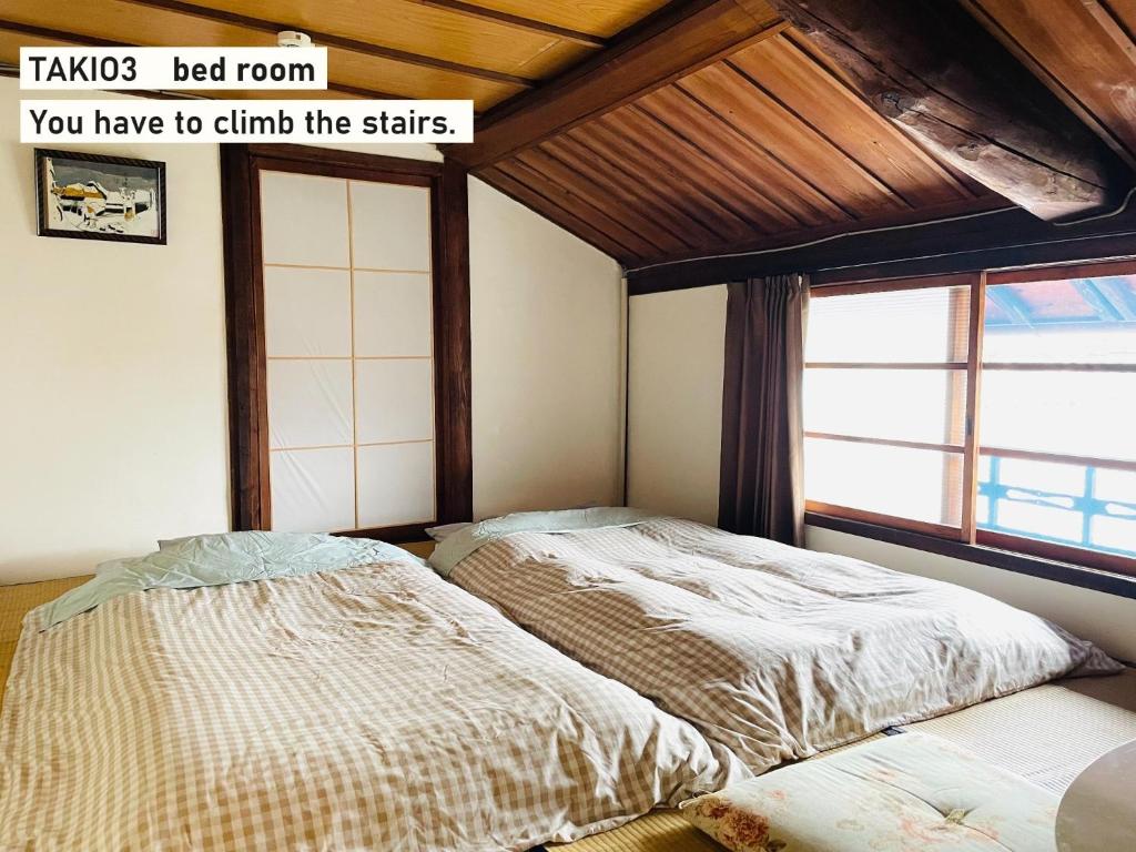 1 dormitorio con 2 camas y ventana en TAKIO Guesthouse - Vacation STAY 11604v en Higashi-osaka