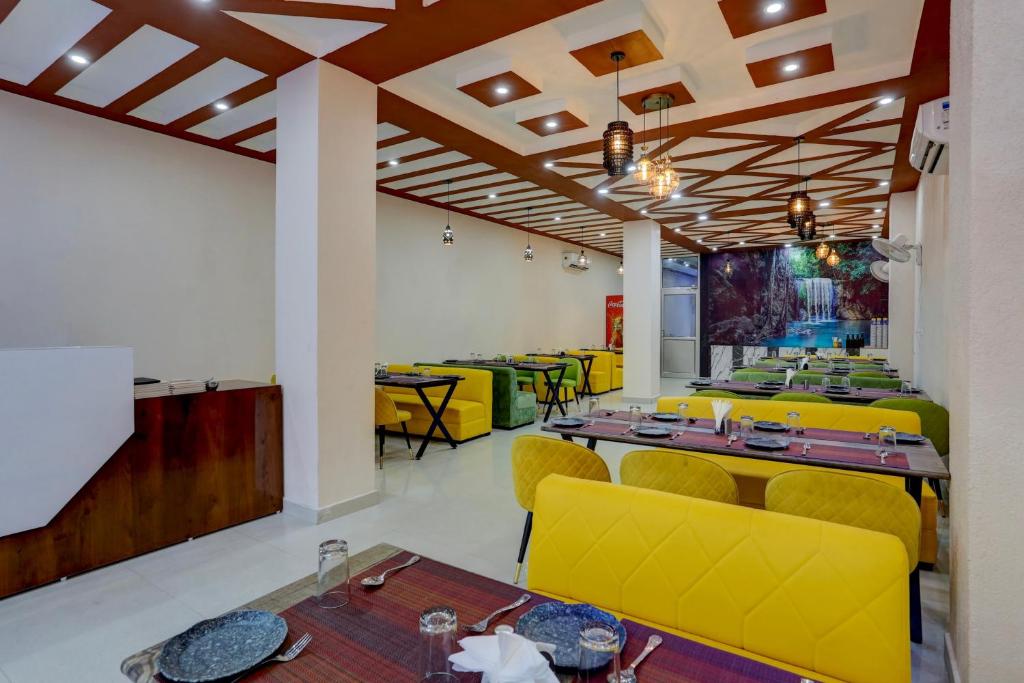 una sala da pranzo con sedie e tavoli gialli di Townhouse Hotel Selaqui Inn a Jhājra