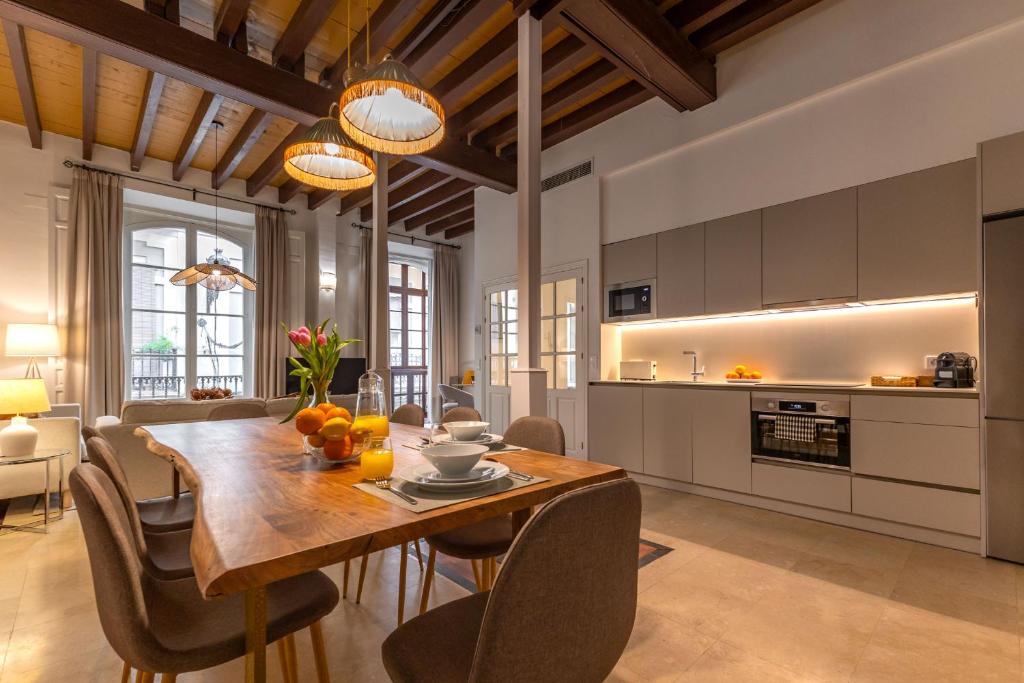 a kitchen and dining room with a wooden table and chairs at Casa Rental home Campana in Seville