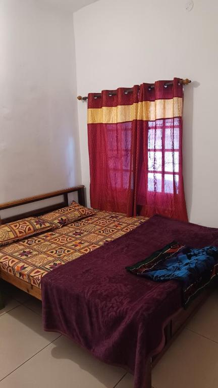 a bed sitting in a room with a window at Lebon's Tamilkudil in Masinagudi