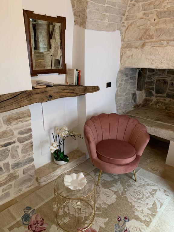 a living room with a chair and a stone fireplace at Il Torrione in Terlizzi