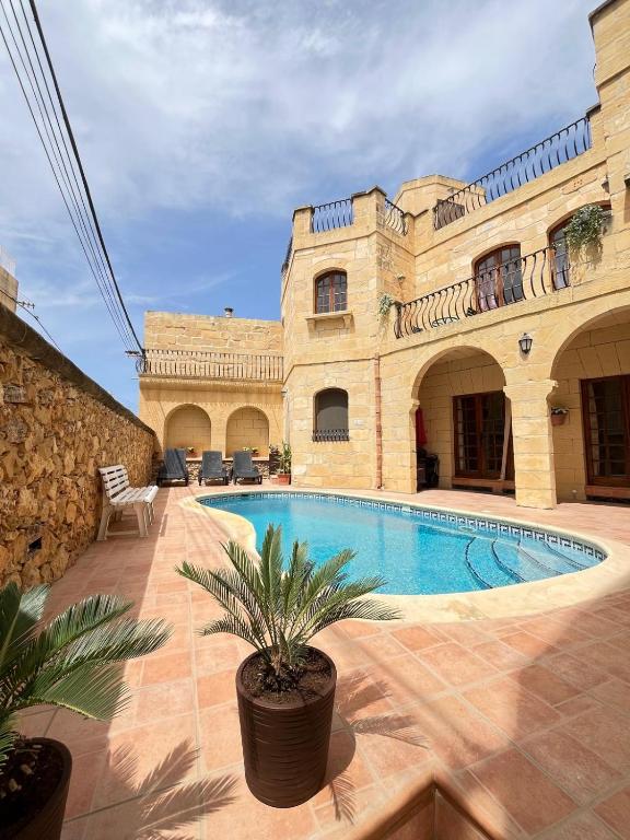 a house with a swimming pool in a courtyard at Sant Antnin B&B in Munxar