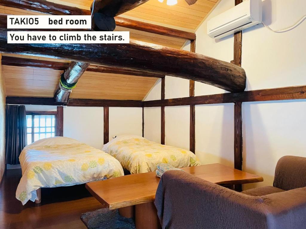 um quarto com duas camas e uma mesa em TAKIO Guesthouse - Vacation STAY 12215v em Higashi-osaka