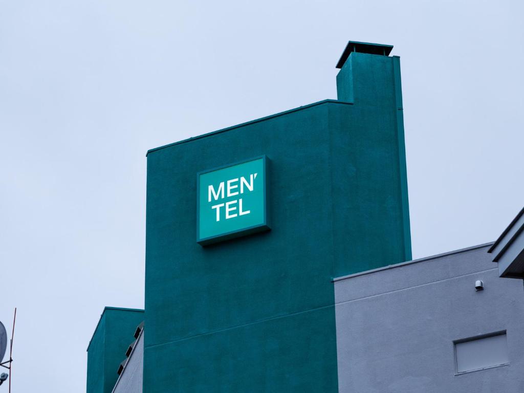una señal verde en el lateral de un edificio en Tabist MEN‘TEL Kitami, en Kitami