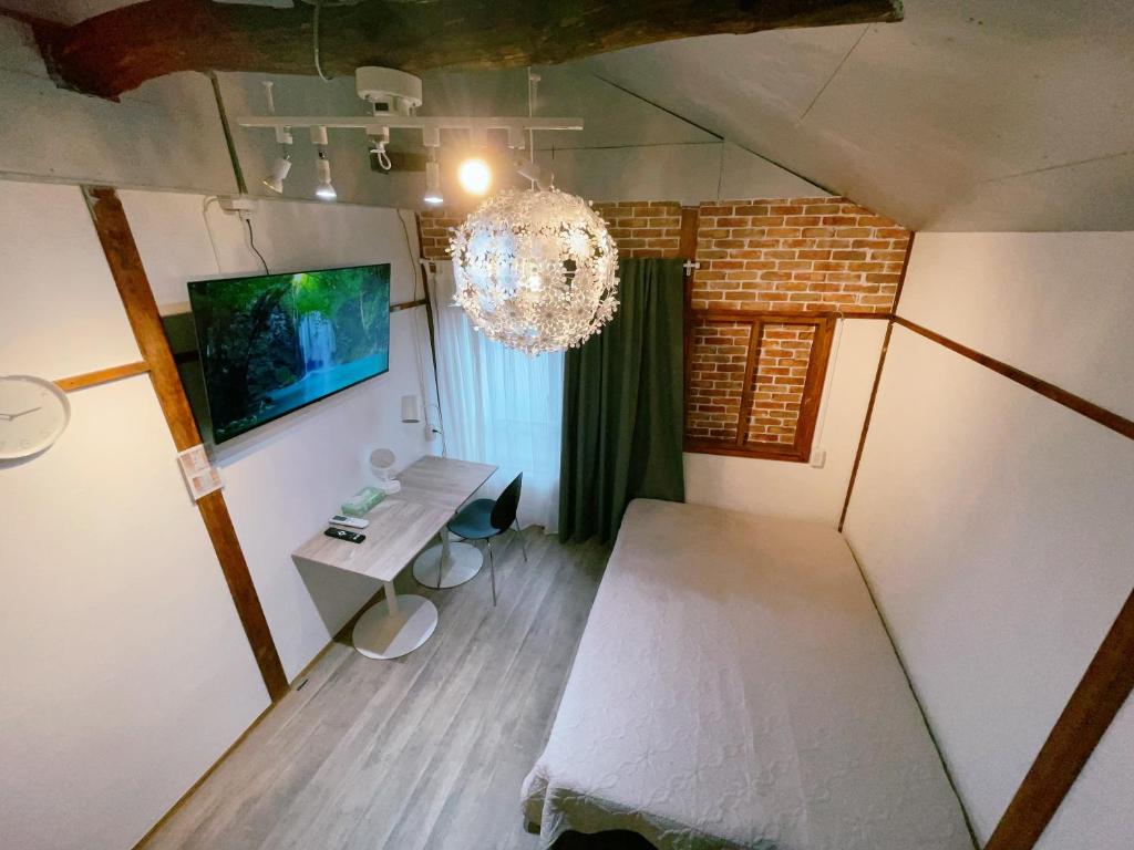 an attic room with a table and a chandelier at Akira&chacha杉並区世田谷direct to shinjuku for 13 min 上北沢4分 近涉谷新宿 in Tokyo