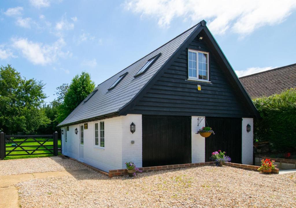 een zwart-witte schuur met een zwart dak bij The Honey Pot in Lyminge