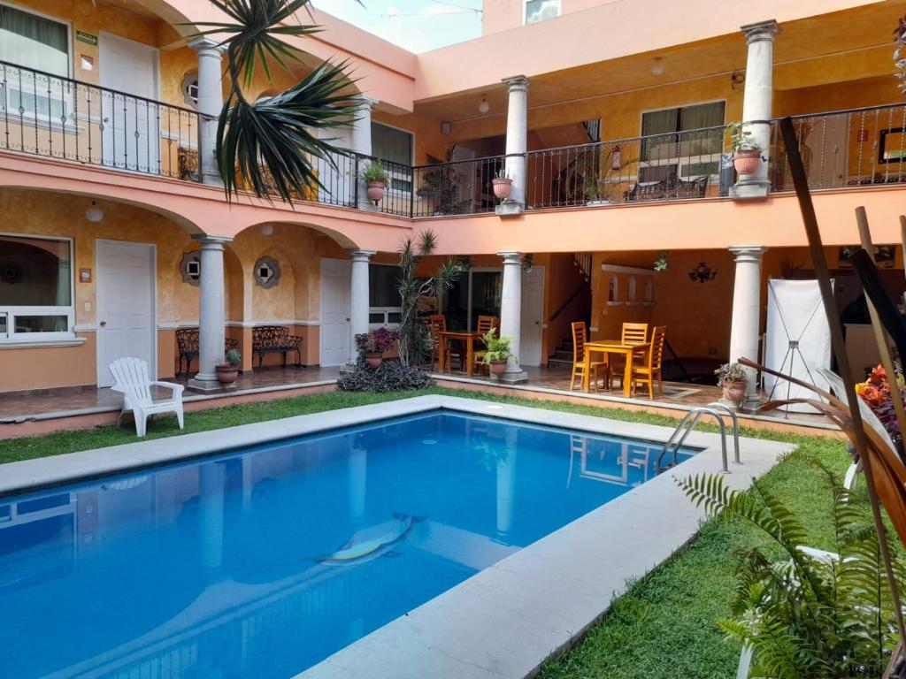 a villa with a swimming pool in front of a building at Los Anturios in Cuernavaca