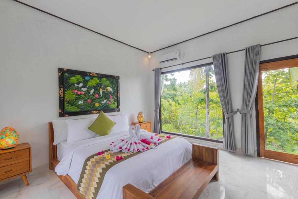 a bedroom with a bed and a large window at Radjes Bungalow Nusa Penida in Nusa Penida